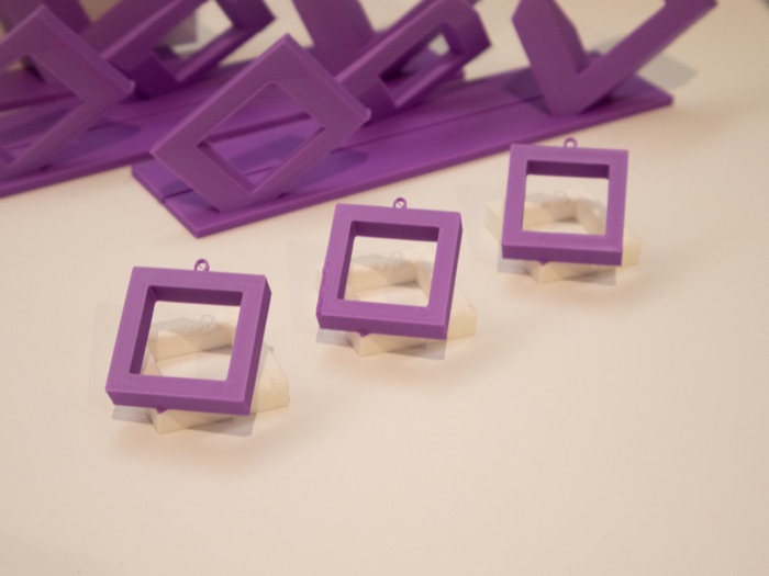 Finished purple 3D-printed hanging MW ornaments and keychains