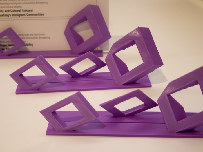 Purple 3D-printed project card stands displaying student project descriptions