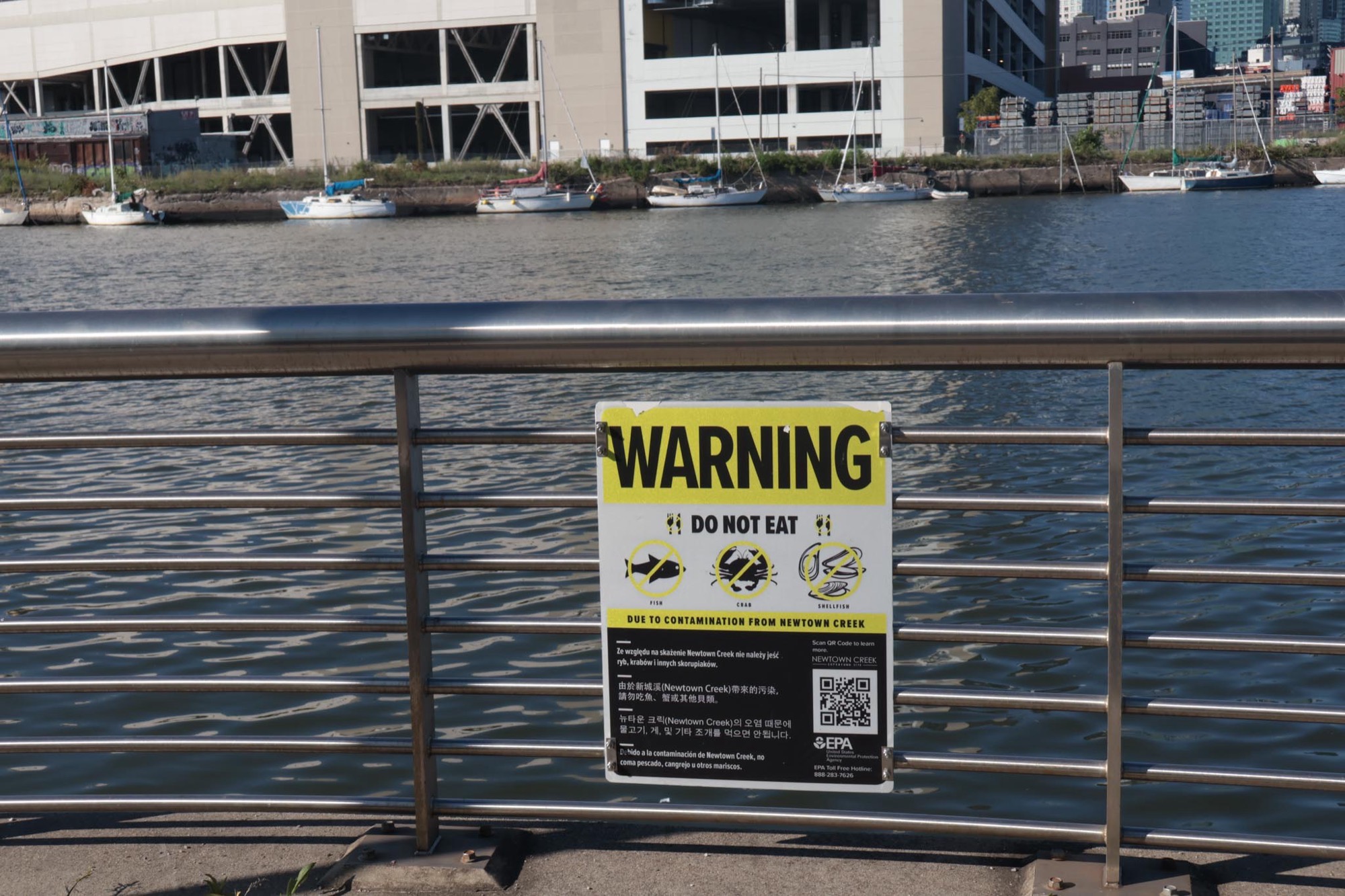 A warning sign posted along Newtown Creek reading DO NOT EAT the fish